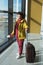 Vertical full length portrait of an elderly woman with a suitcase, passport and boarding pass