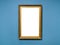 Vertical golden wood picture frame on blue wall