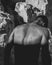 Vertical grayscale shot of the back of a shirtless fit male