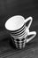 Vertical grayscale shot of mugs with striped and chess tile patterns