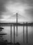 Vertical grayscale shot of the River Suir Bridge with a dramatic overcast in Waterford, Ireland