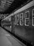 Vertical grayscale shot of a train at an indoor station