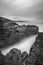 Vertical grayscale of the tops of rocky cliffs with smoky clouds