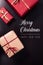Vertical greeting card for christmas, flat lay with typography and presents on dark wood