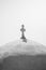 Vertical greyscale shot of a cross on the dome of a Greek Orthodox church
