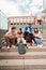 Vertical. Group of multiracial high school students talking on a staircase at university campus, using a tablet app and