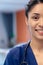 Vertical half face portrait of smiling biracial female doctor in hospital ward, copy space