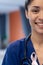 Vertical half face portrait of smiling biracial female doctor wearing cancer ribbon, copy space