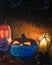 Vertical Halloween spooky pumpkins wearing face masks and candles in a dark setting