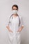 Vertical head shot concept. Young beautiful woman doctor in medical mask in a white coat on an isolated white background