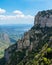 Vertical high-angle of Montserrat forested mountain peak sunlit clear sky background