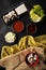 Vertical high angle shot of sauces, lettuce and boiled meat pieces with cheese on the table