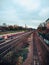 Vertical high angle shot of a train and the train tracks surrounded by buildings and trees