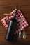 Vertical High angle view of a red wine bottle on a red and white checkered napkin