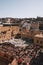 Vertical high-angle view of the traditional tannery vats and the cityscape of Fes under the blue sky