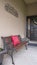 Vertical Home facade with bench welcome sign and potted plants on the porch