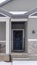 Vertical Home facade with gable roof front porch and door with wreath in winter