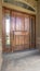 Vertical Home porch and brown wood front door with sidelights and arched transom window