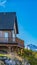 Vertical House on a hill with balcony overlooking snowy mountain and bright blue sky