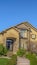 Vertical House with stairs on the landscaped yard leading to the wrought iron front door