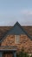 Vertical House with steeply pitched roof near sunset