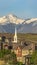 Vertical Houses and church with scenic landscape of snow capped mountain and blue sky