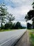 The vertical image of cement road view with trees flanked And the sign of kilometer 1 as strat point for beginning.jpg