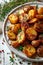 vertical image closeup of tasty rustic potatoes with spices on a white wooden background