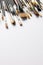 Vertical image of composition of diverse brushes on white surface with copy space