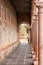 Vertical image of the corridor of a temple lined with columns leading to an arched doorway