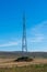 Vertical image of an electricity pylon on empty agricultural field