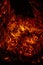 Vertical image of embers of a burning log creating a fiery background