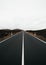 Vertical image of empty road with perfect symmetric lines at overcast day. Travel shot from trip of Lava island - Lanzarote (