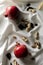 Vertical image.Fresh ripe pomagranates, raisins, nuts on the white tablecloth.Dramatic light