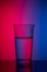 Vertical image glass of water on blue pink background