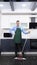 Vertical image. handsome man in tie and apron mops the floor in the kitchen