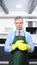 A vertical image. handsome man in tie and apron wearing rubber gloves