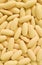 Vertical image of heap of creamy yellow oval shaped supplement pills