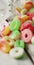 Vertical image of jelly candy spilling out of glass jar on wooden background