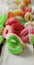 Vertical image of jelly candy spilling out of glass jar on wooden background