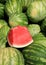 Vertical image of large watermelons, one sliced open to show freshness