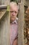 Vertical image of a mature man spying round a wooden door