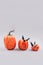 Vertical image, minimal Halloween scary and concept. Decorative orange pumpkins with bats on light gray background with