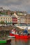 Vertical image of the old iconic traditional waterfront shophouses with red vessel at Cobh, Republic of Ireland