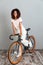 Vertical image of Pretty Smiling african woman riding on bicycle