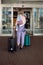 Vertical image of rearview woman walking with luggage walk to waiting room at the airport terminal. Start summer weekend