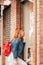 Vertical image of a shopping woman touching up her makeup in a cosmetic store window. concept of shopaholic and lifestyle