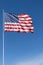 Vertical image of the stars and stripes of the American flag against a deep blue sky.