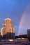 Vertical image of a tall building in Valencia with a rainbow next to it