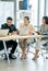 Vertical image of three Asian business man and women sit together and discuss about project in laptop and they look happy in